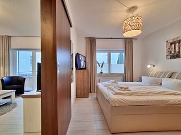 Schlafzimmer mit Doppelbett, Kleiderschrank und zusätzlichem TV