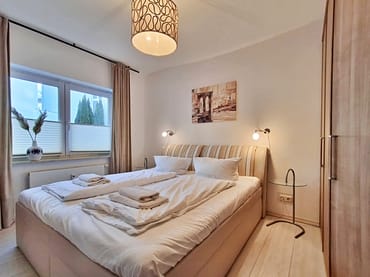 Schlafzimmer mit Doppelbett, Kleiderschrank und zusätzlichem TV