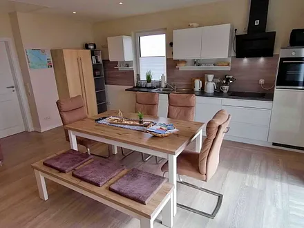 Wohn- und Essbereich mit gemütlicher Couch, Küchenzeile, Zugang zur Hochterrasse