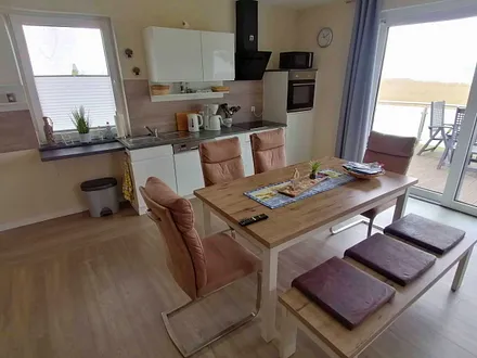 Wohn- und Essbereich mit gemütlicher Couch, Küchenzeile, Zugang zur Hochterrasse