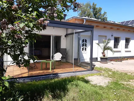 Eingang zum Bungalow und Veranda mit Schiebefenstern