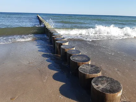 Wasser brandet an die Buhnen