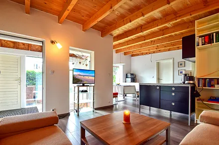 Wohnzimmer mit Schlafsofa und Küche mit Essecke