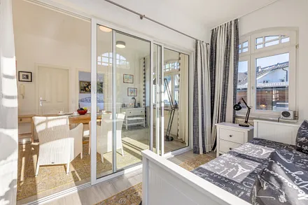 Blick aus Schlafzimmer 2 in den Eßbreich. Die gläserne Wand hat ebenfalls Verdunkelungsgardinen, die als Sicht- und Lichtschutz genutzt werden können.