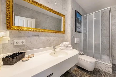 Das schicke Bad mit großem Waschtisch, Fön und WC.