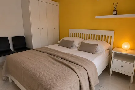 1. Schlafzimmer mit Doppelbett und direktem Zugang zum Balkon.