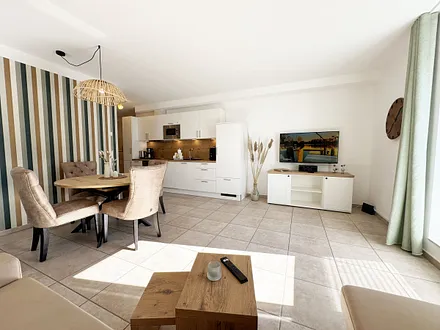 gemütlicher Wohnbereich mit angrenzender Küchenzeile und Esstisch