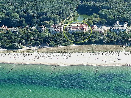 Luftbild vom Dünenschloss (Kreis) direkt am Strand (hinter dem Haus beginnt zudem unmittelbar der weitläufige Stadtwald)