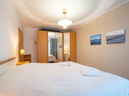 Das Schlafzimmer mit Doppelbett und Kleiderschrank