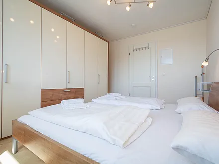 Das Schlafzimmer mit Doppelbett und großem Kleiderschrank