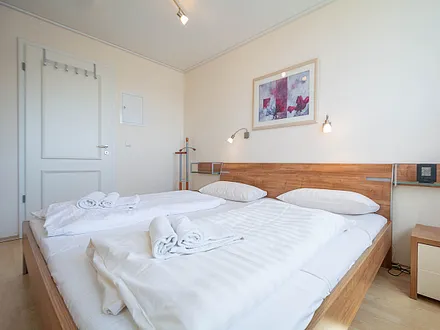 Das helle freundliche Schlafzimmer mit Doppelbett