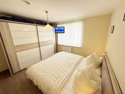 Schlafzimmer mit Doppelbett und Kleiderschrank