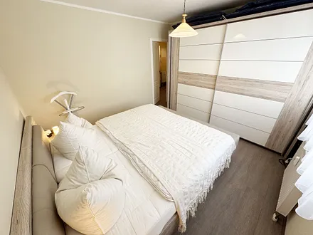 Schlafzimmer mit Doppelbett und Kleiderschrank