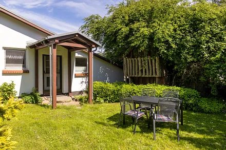 Ihre sonnige Sitzgelegenheit vorm Ferienhaus - gern dürfen Sie hier grillen. 