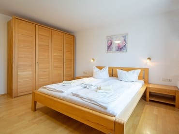 Das Schlafzimmer mit Doppelbett und Kleiderschrank