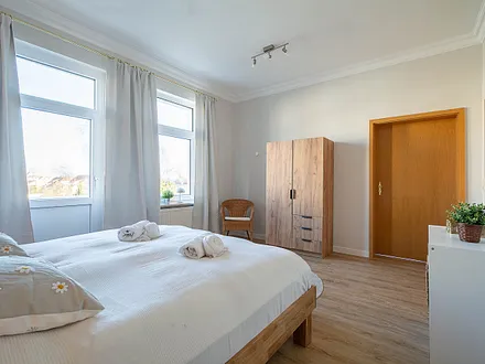 Das erste Schlafzimmer mit Doppelbett und Kleiderschrank