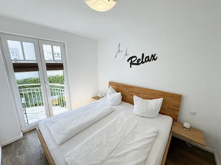 Schlafzimmer mit Doppelbett und Zugang auf den Balkon