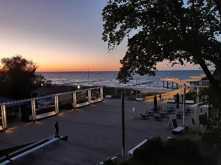 Blick vom Balkon auf die beleuchtete Seebrücke am Abend