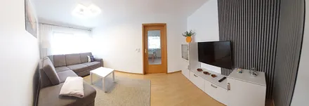 Wohnzimmer mit großer Eckcouch und LED-TV 