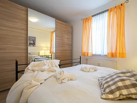 Das erste Schlafzimmer mit Doppelbett und Kleiderschrank