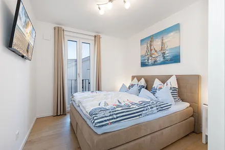 Schlafzimmer mit Doppelbett und Smart-TV