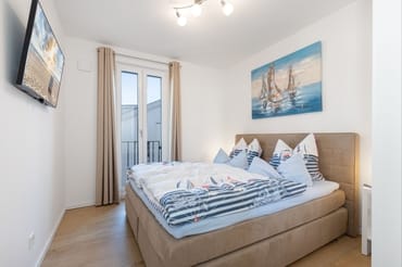 Schlafzimmer mit Doppelbett und Smart-TV