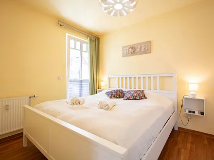 Das erste Schlafzimmer mit Doppelbett  und Terrassenzugang