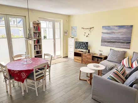 heller Wohnbereich mit Bücherregal sowie Brettspiele