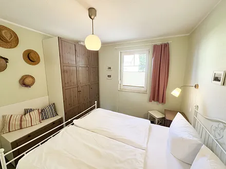 Schlafzimmer mit Doppelbett, sowie Nachtischablagen mit Beleuchtung