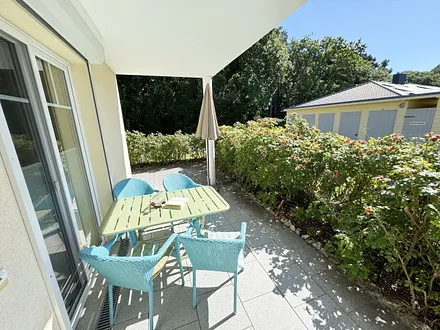 bestuhlte und überdachte Terrasse mit Sonnenschirm