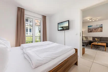 Schlafzimmer Nr. 1 mit Doppelbett (180x200cm), Kleiderschrank, TV und Verdunkelungsvorhängen.