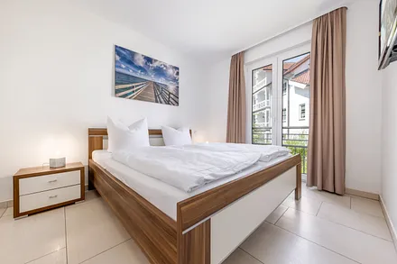 Schlafzimmer Nr. 1 mit Doppelbett (180x200cm), Kleiderschrank, TV und Verdunkelungsvorhängen.