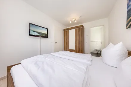 Schlafzimmer Nr. 1 mit Doppelbett (180x200cm), Kleiderschrank, TV und Verdunkelungsvorhängen.