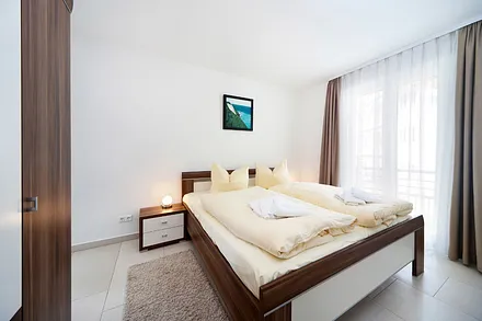 Das 1. Schlafzmmer mit Doppelbett, Kleiderschrank mit Safe und TV.