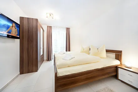 Das 2. Schlafzmmer mit Doppelbett, Kleiderschrank und TV. Bügelbrett und Bügeleisen sind vorhanden.