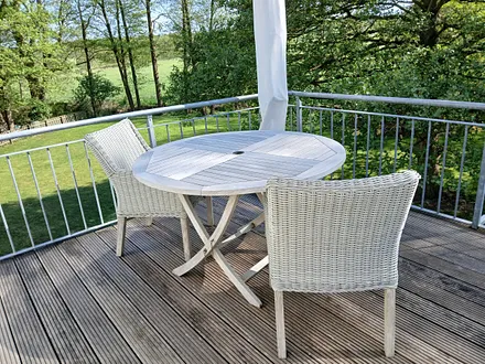 Sitzecke auf dem Balkon und Blick in den Garten