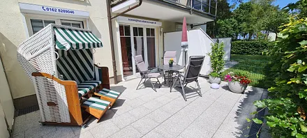 Terrasse mit Tisch, Stühlen und Strandkorb