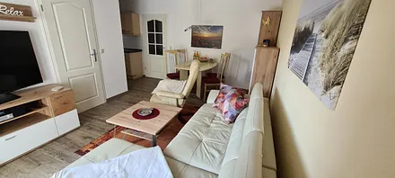 Gemühlicher Wohnbereich mit Blickrichtung vom Terrassenfenster zur Flurtür 