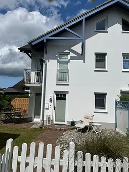 Blick auf die 3-geschossige Viertelhaushälfte, ein Teilstück des Garten und die Haustür