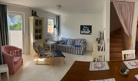 Wohnzimmer, rechtsseitig führt eine Massivholz-Treppe in die beiden oberen Etagen