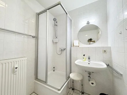 Badezimmer mit Dusche und Waschbecken