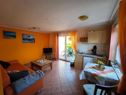 Wohnzimmer mit ausziehbarer Schlafcouch und Küche mit Esstisch 