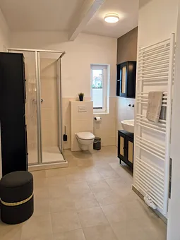 Bad mit begehbarer Dusche, WC, Waschtisch.