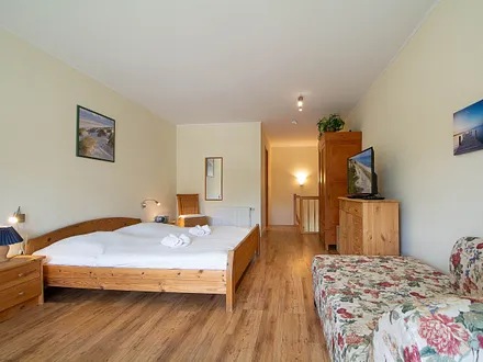 Das Schlafzimmer in der oberen Etage mit Doppelbett und Couch