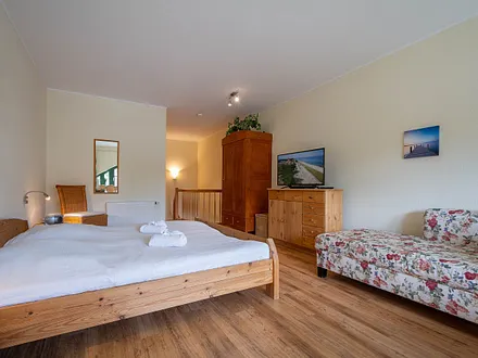 Das Schlafzimmer in der oberen Etage mit Doppelbett und Couch