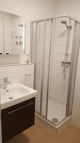 Das moderne Bad mit Dusche und WC.