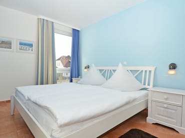 Schlafzimmer mit Doppelbett und Nachttischablagen