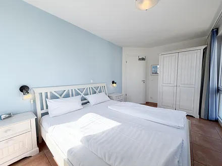 Schlafzimmer mit Doppelbett und Kleiderschrank