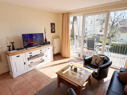 geräumiger Wohnraum mit Couch, Sesseln und Sideboard