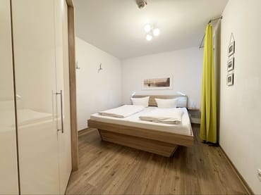 Schlafzimmer mit Doppelbett und Kleiderschrank